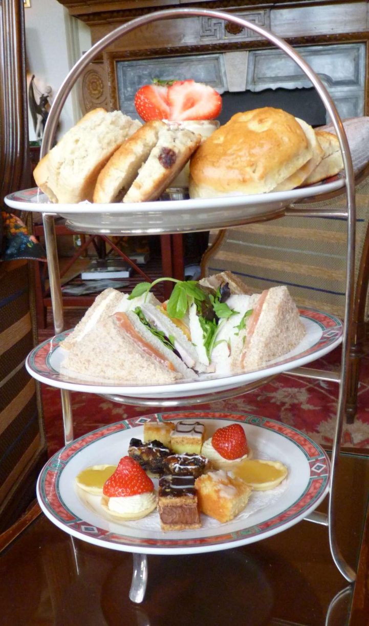 Small cakes, scones and sandwiches served on a 3-tier tower.